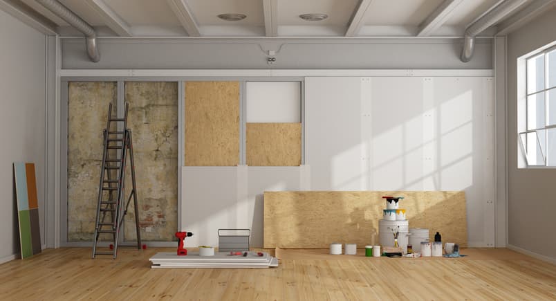 An apartment wall is being renovated with new drywall and materials.