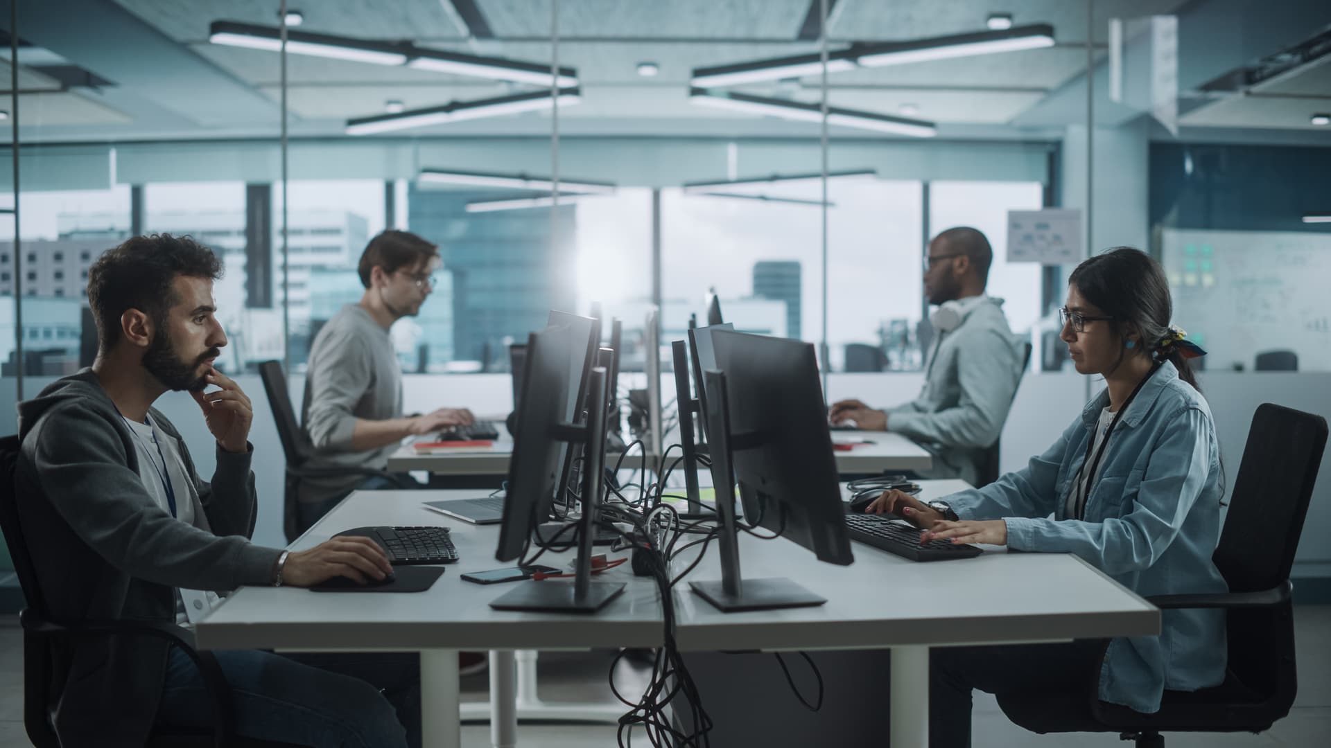 Diverse Multi-Ethnic Team Working in Big City Office: IT Programmers Working on Desktop Computers. Specialists Creating Innovative Software. Engineers Developing Inspiration App, Program.