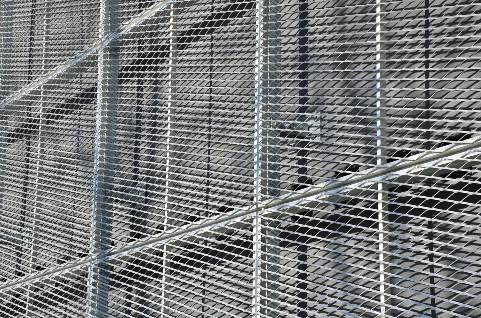 Closeup of wire mesh netting outside building.