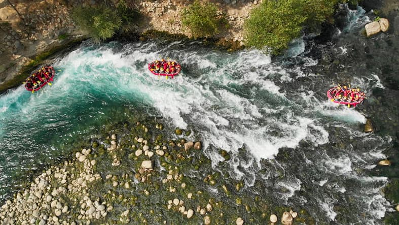Rafters paddle down a river.