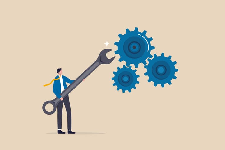 man shoving spanner in cogs