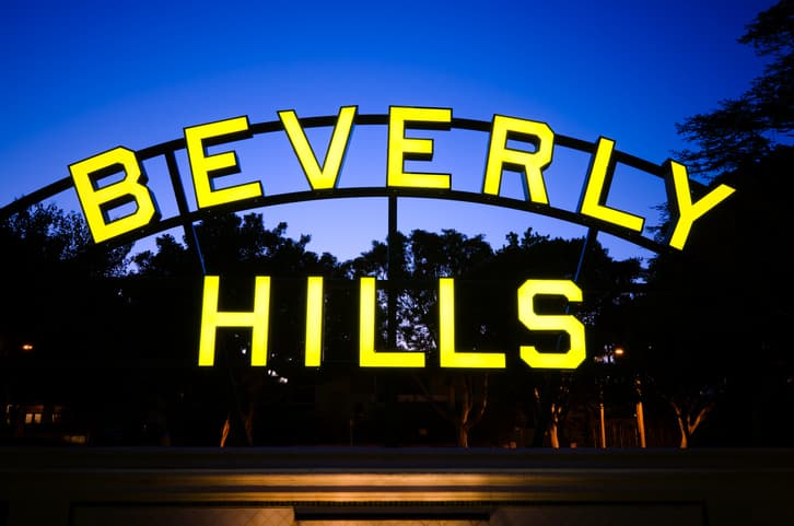 Beverly Hills sign located along Santa Monica Boulevard in Beverly Hills, CA at night.