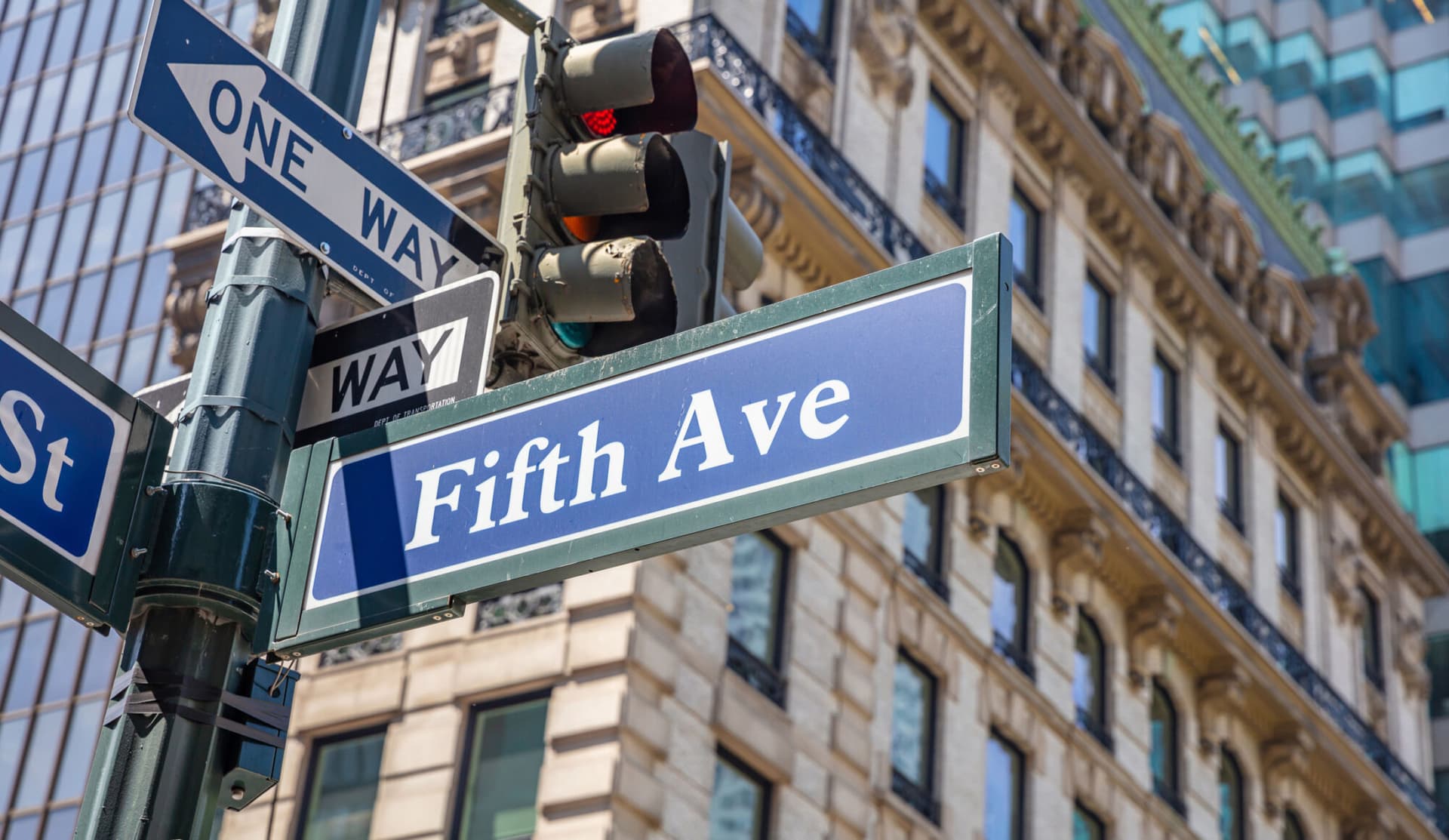 Fifth ave street sign, Manhattan New York downtown. Blue sign on blur buildings facade background,