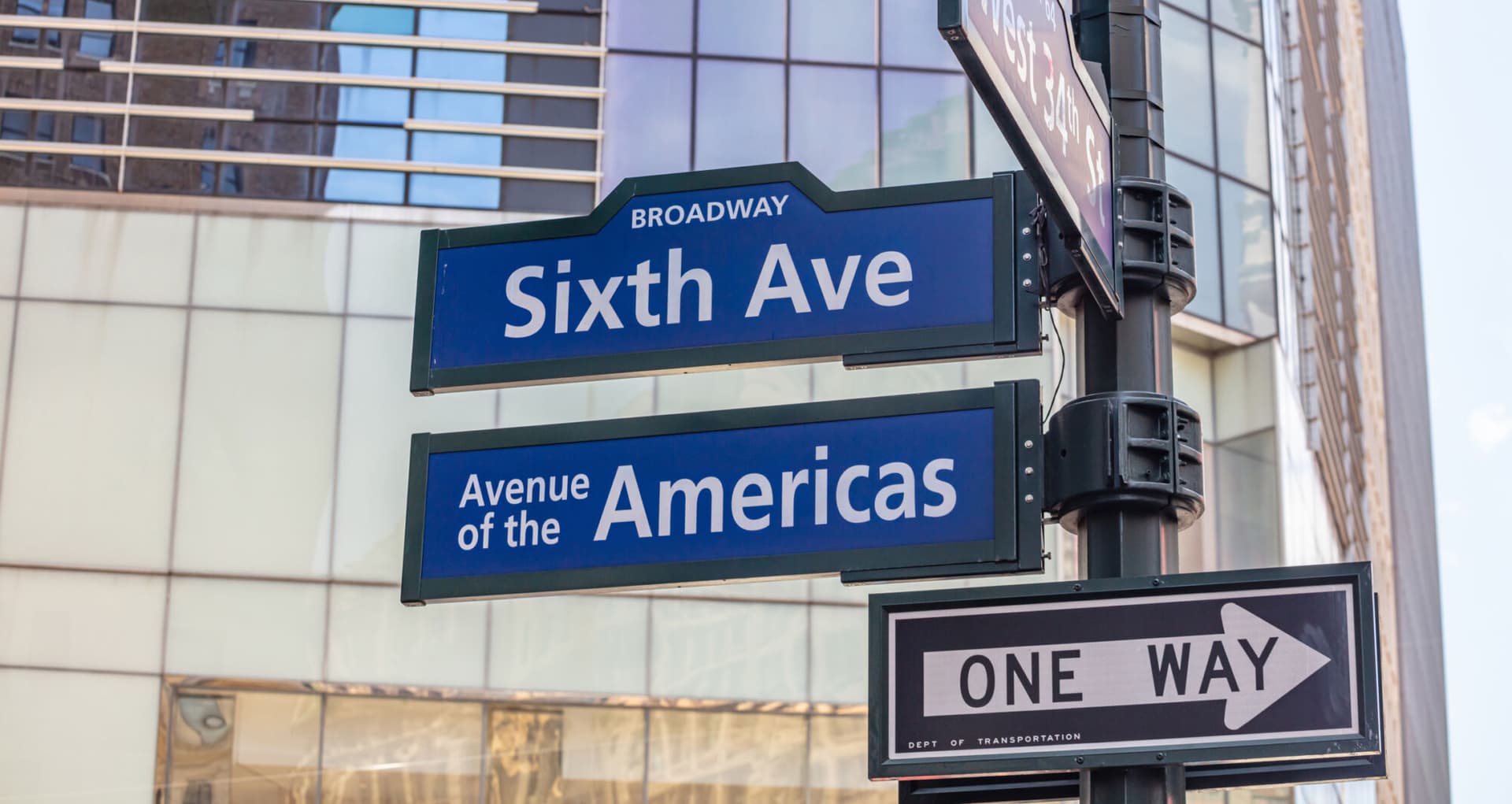 Sixfth ave Broadway street sign, Manhattan New York downtown. Blue signs on blur buildings facade background, Avenue of the Americas
