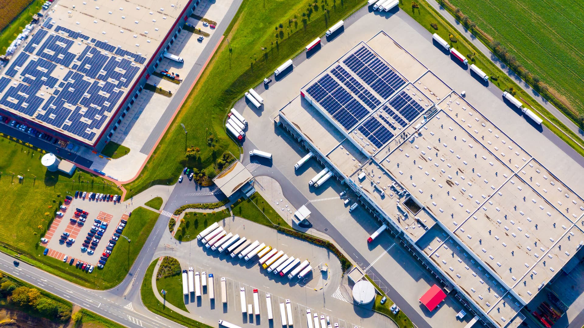 Industry with low carbon footprint. Industrial warehouses with solar panels on the roof. Technology park and factories from above