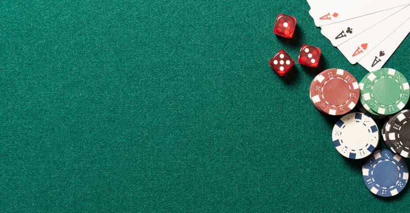 Poker table in casino top view. Green table with poker chips, cards and dices, background with copy space.