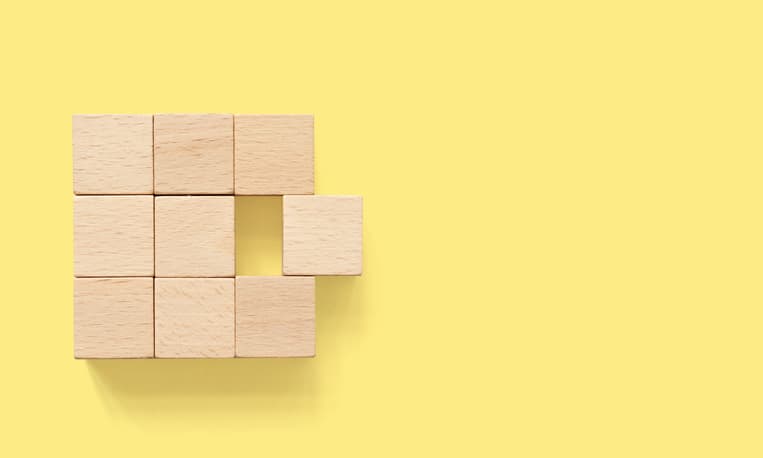 Merger abstract. Group of wooden cube block on yellow background with copy space
