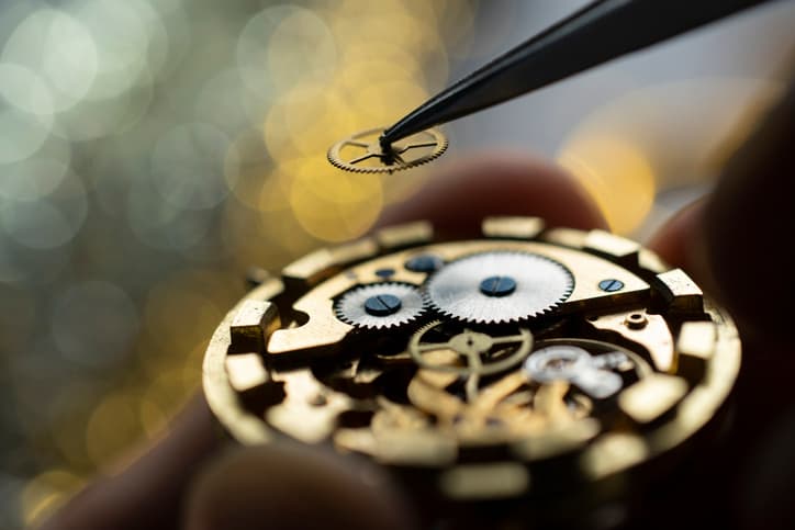 Pocket watch being repaired by senior watch maker, close-up. Black and white.