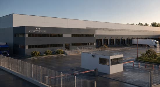 A photo of a large industrial building and it's accompanying car park