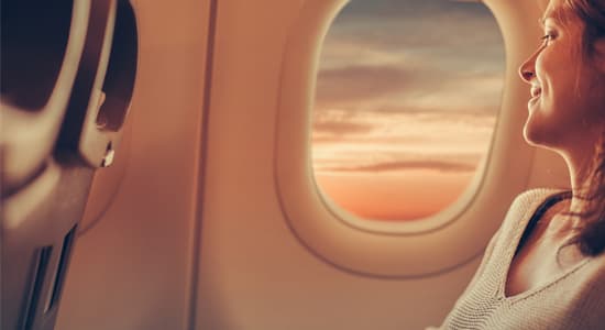 Woman in the window seat of a plane looking out