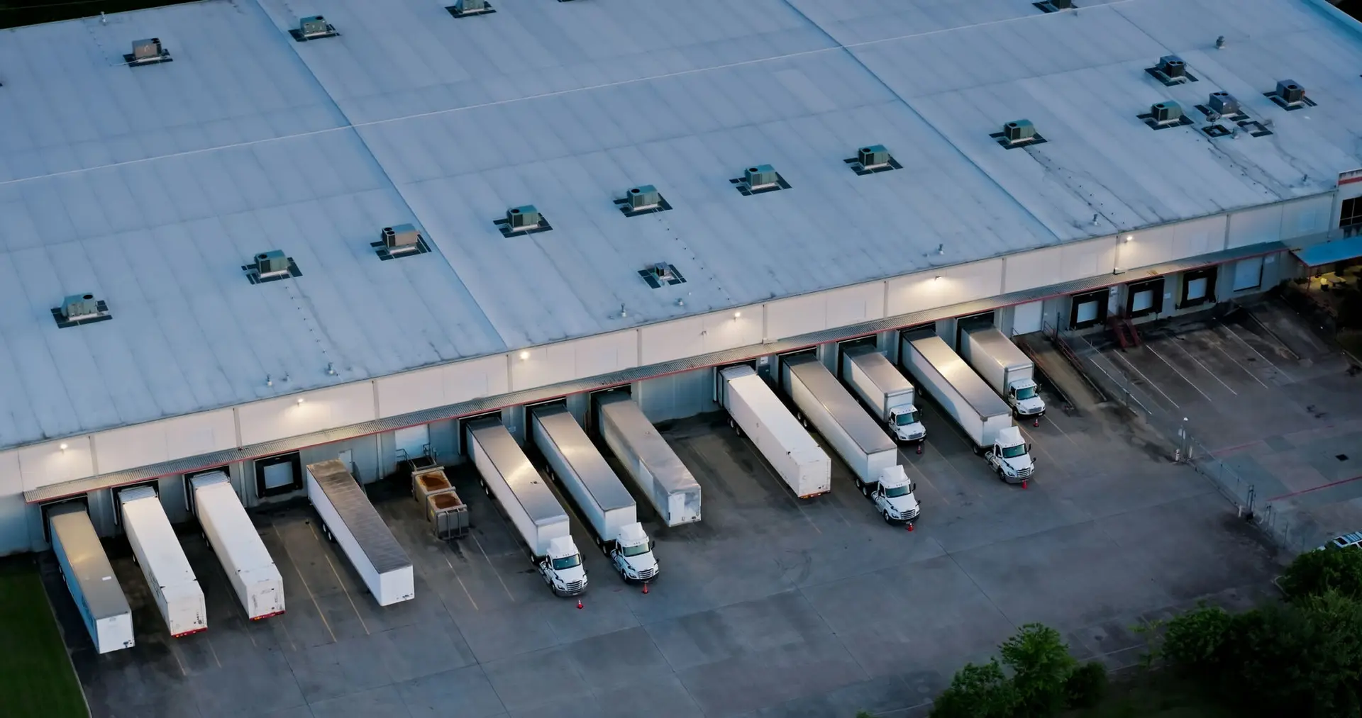 Aerial shot of large semi-trucks parked in a warehouse in Houston, Texas in the evening. Logistics. Industrial.