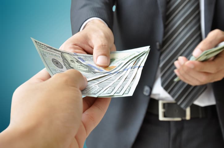 Hands giving &amp; receiving money - United States Dollars (or USD) bills