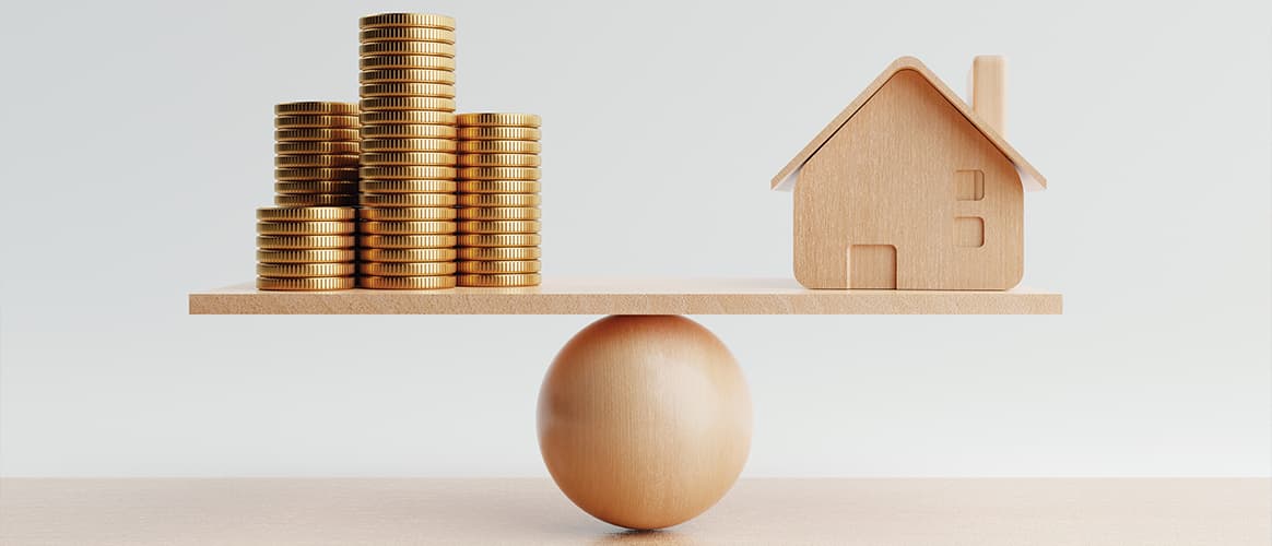 Balancing a house on one side of a seesaw with piles of money on the other
