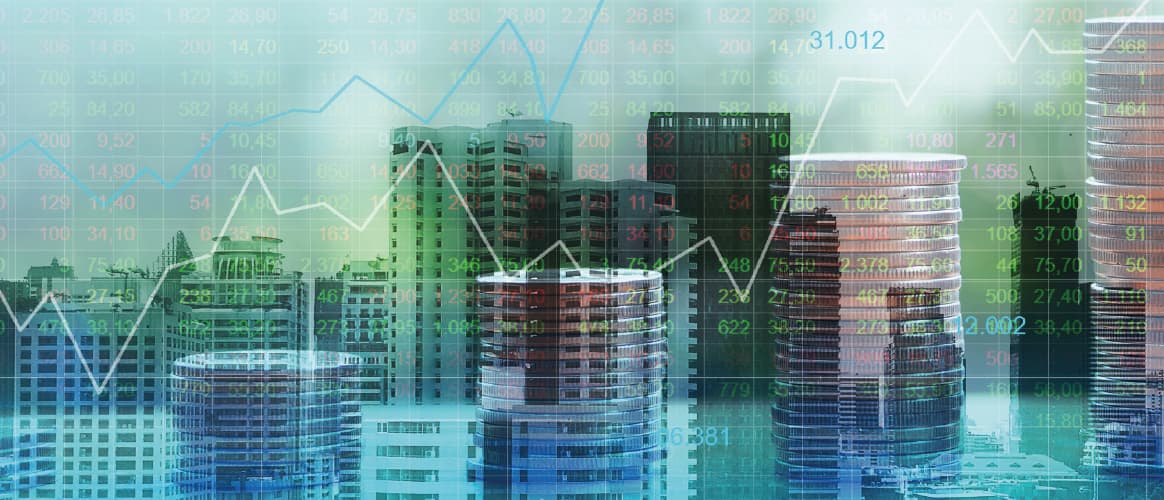 Double exposure image of buildings and piles of coins with a line graph hovering over the top