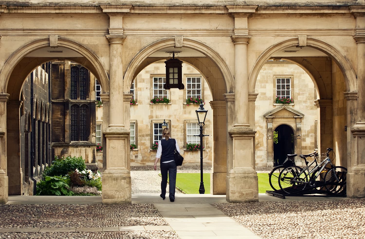 Student passing through a college campus in Cambridge Universitiy, UK.