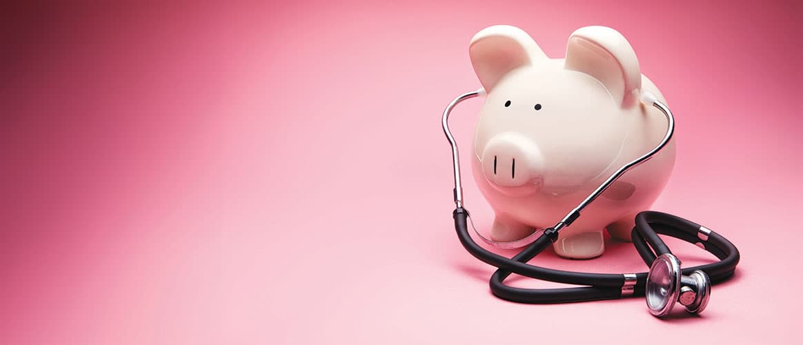 This is a photo of a large white piggy bank on a pink background. This is a concept photo related to finance and the medical hospital industry,