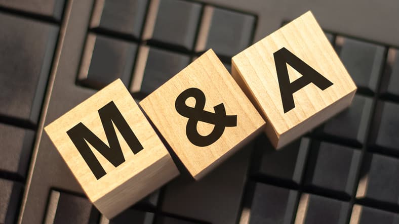Image of blocks spelling out M&A, representing mergers and acquisitions.