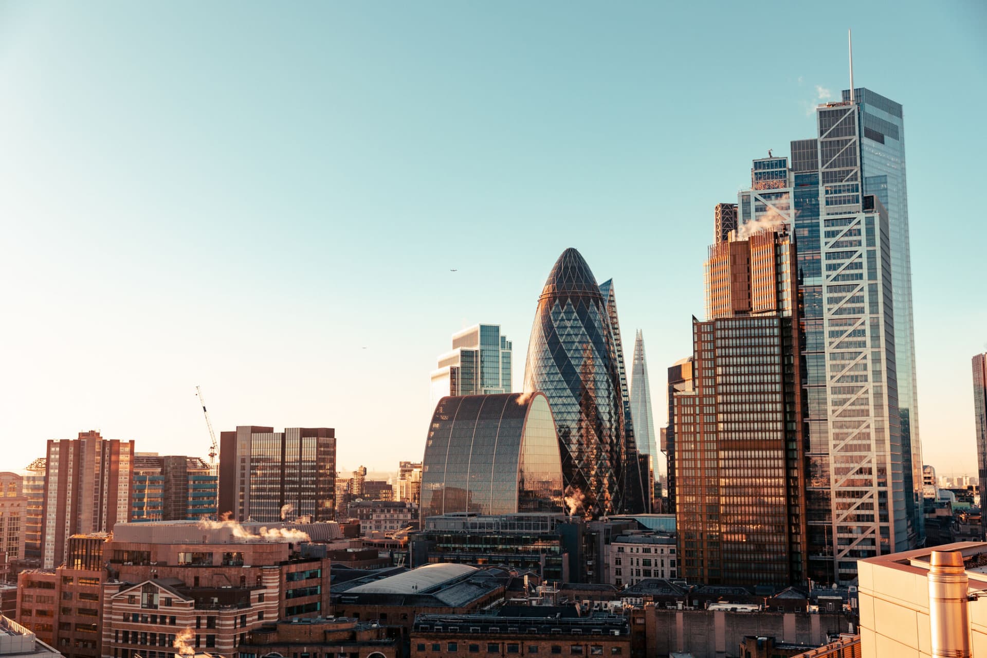 Wide angle of sun setting over London Gherkin.