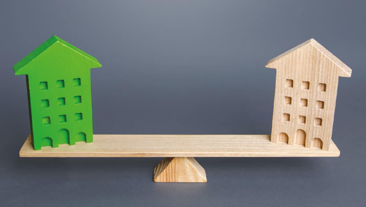 Image of two wood block buildings on a wooden scale.