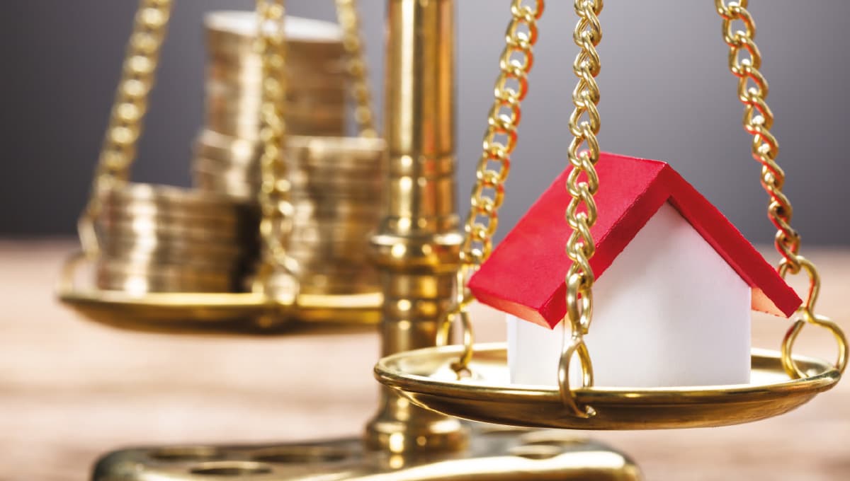 Image of scales balancing coins and a house.