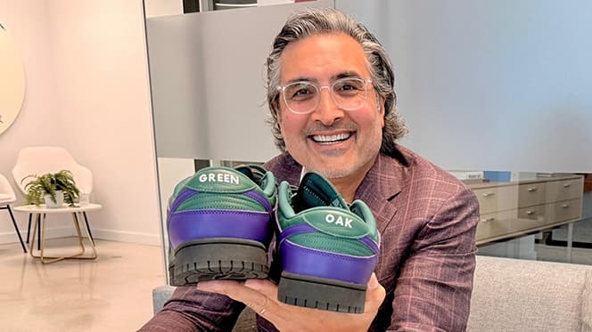 Image of Sonny Kalsi holding sneakers saying Green Oak.